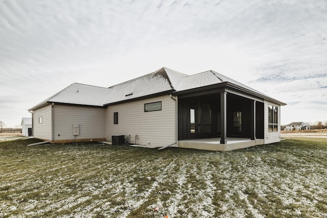 snow covered house featuring a sunroom and central AC unit