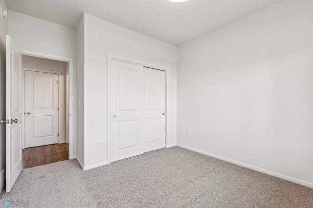 unfurnished bedroom featuring carpet flooring and a closet