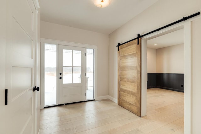 foyer featuring light wood finished floors and a barn door