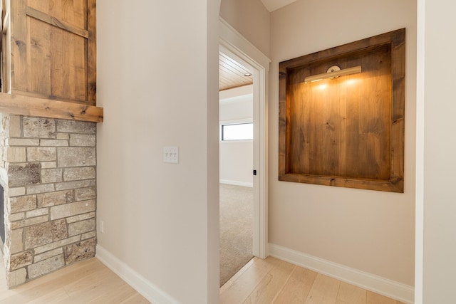 hall featuring light wood-type flooring and baseboards