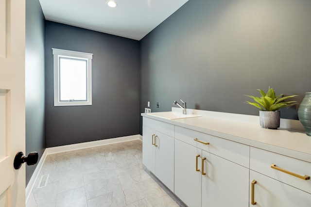 bathroom with marble finish floor, vanity, and baseboards