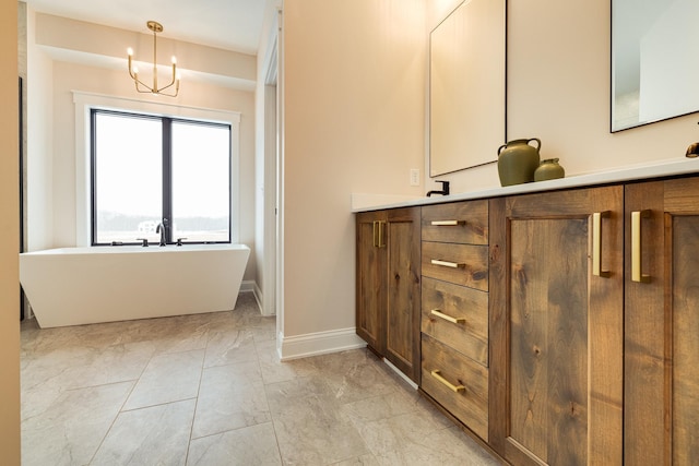 bathroom featuring a freestanding tub, vanity, and baseboards