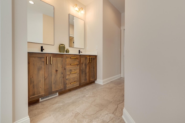 full bath featuring double vanity, visible vents, and baseboards