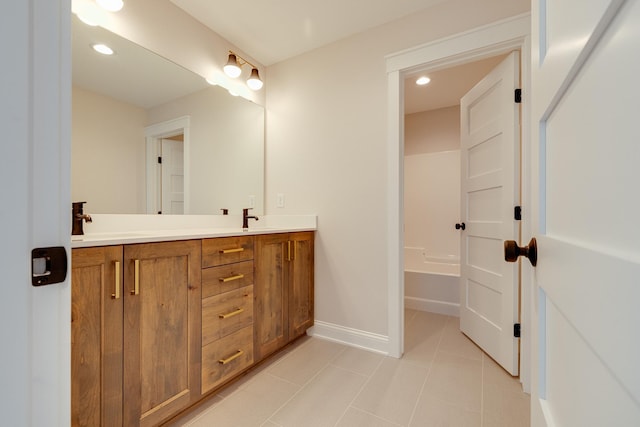 bathroom featuring double vanity, baseboards, tile patterned flooring, a sink, and recessed lighting