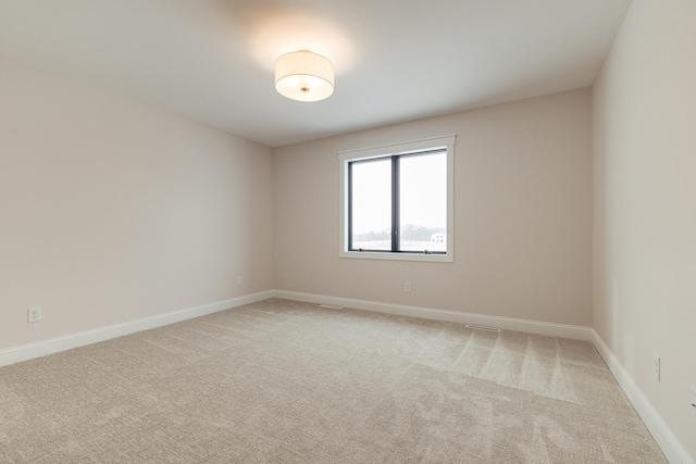 carpeted empty room featuring baseboards