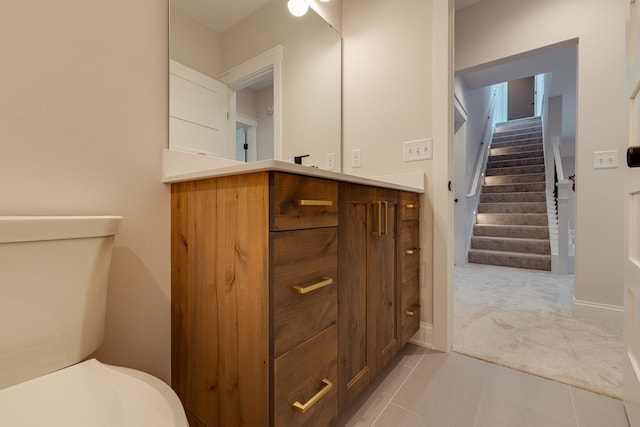 bathroom with baseboards, vanity, and toilet