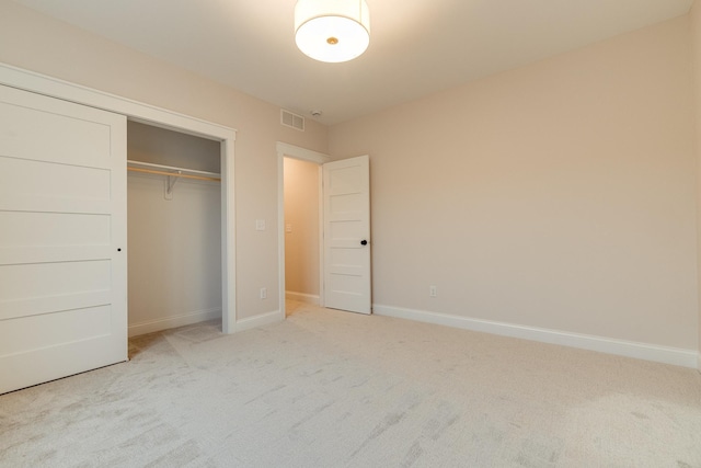 unfurnished bedroom with a closet, carpet, visible vents, and baseboards