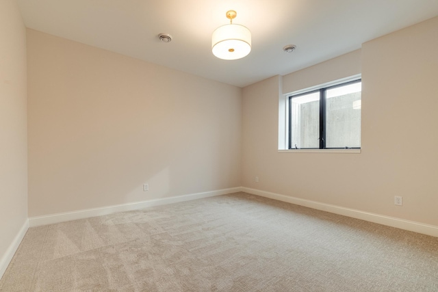 unfurnished room featuring light colored carpet, visible vents, and baseboards