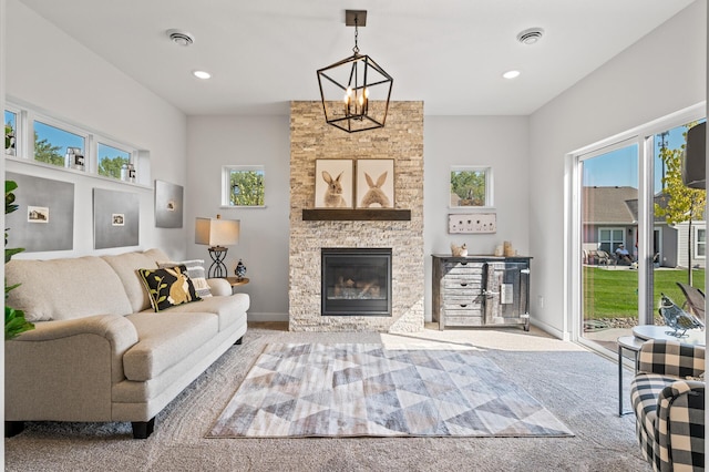 living room with a stone fireplace, carpet flooring, and an inviting chandelier