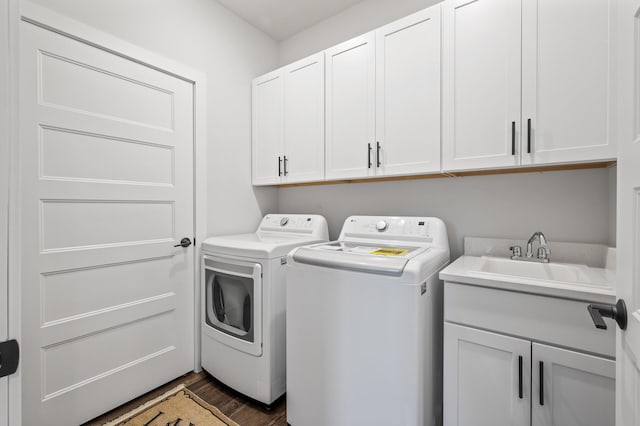 washroom with cabinets, sink, independent washer and dryer, and dark hardwood / wood-style flooring