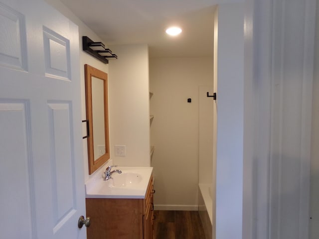 bathroom featuring  shower combination, wood-type flooring, and vanity with extensive cabinet space