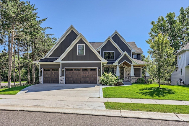 craftsman inspired home featuring board and batten siding, stone siding, driveway, and a front lawn