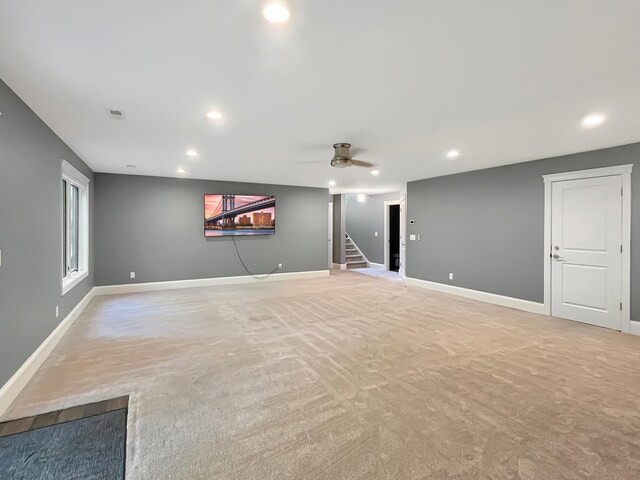 unfurnished living room featuring recessed lighting, stairs, baseboards, and light colored carpet