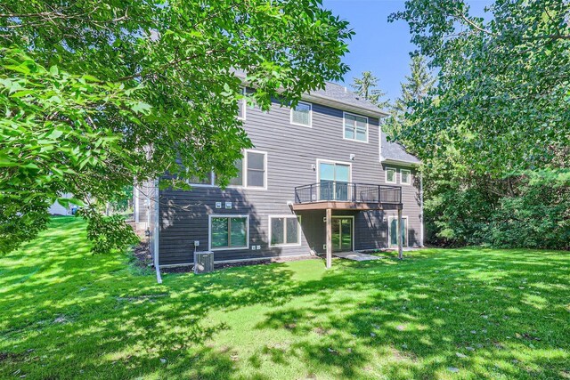 back of house featuring a deck and a yard