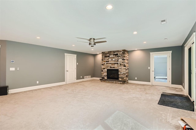 unfurnished living room featuring baseboards, a fireplace, visible vents, and light colored carpet