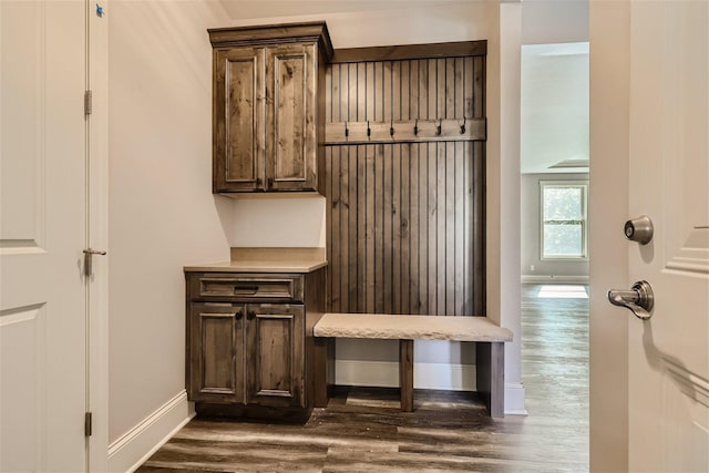 mudroom with dark wood-style flooring and baseboards