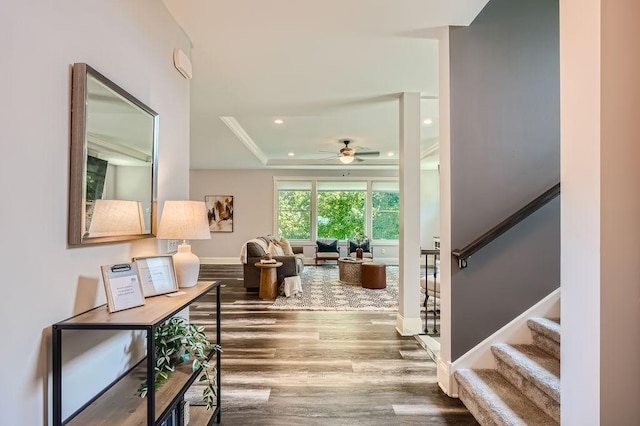 interior space with baseboards, stairway, wood finished floors, a tray ceiling, and recessed lighting