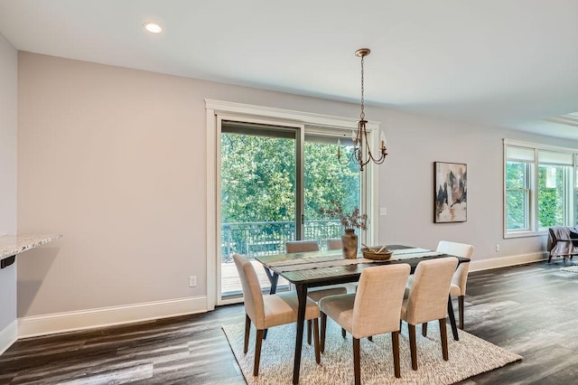 dining space with dark wood-type flooring, recessed lighting, a notable chandelier, and baseboards