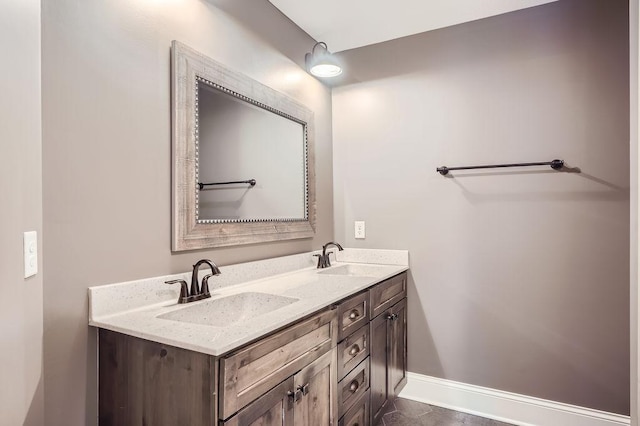 full bath with a sink, baseboards, and double vanity