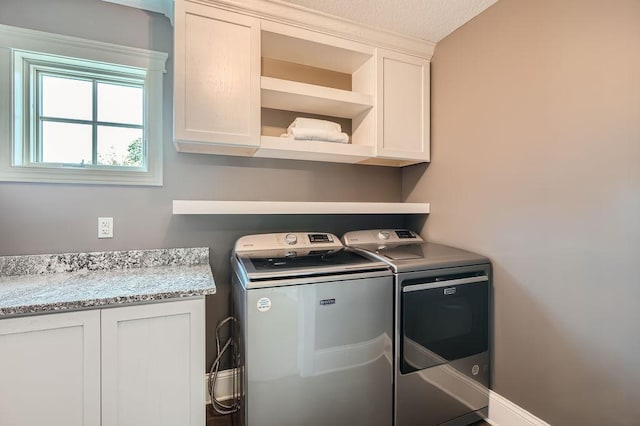 laundry room featuring separate washer and dryer and cabinet space