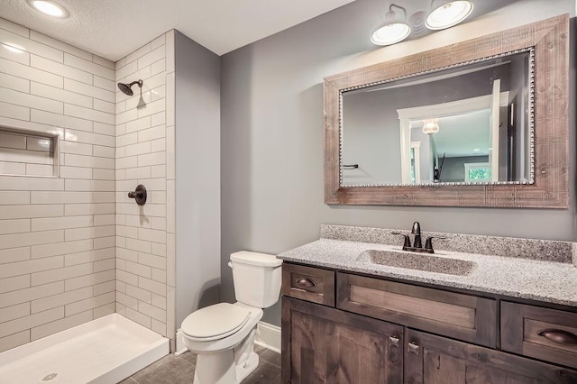 full bathroom featuring toilet, a shower stall, baseboards, and vanity