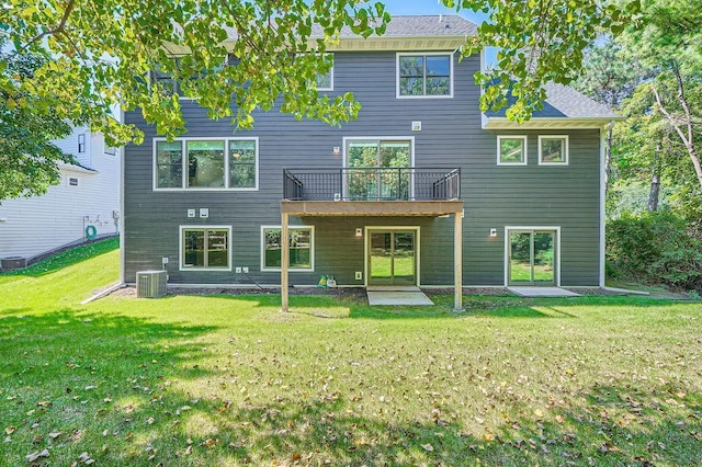 rear view of property featuring cooling unit and a lawn