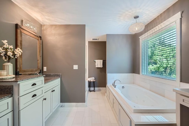 full bathroom with visible vents, a jetted tub, vanity, and baseboards