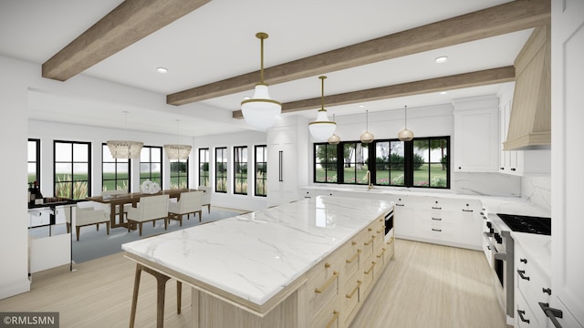 kitchen featuring light stone counters, white cabinets, a center island, and pendant lighting