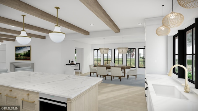 kitchen with sink, a center island, light stone countertops, decorative light fixtures, and beamed ceiling