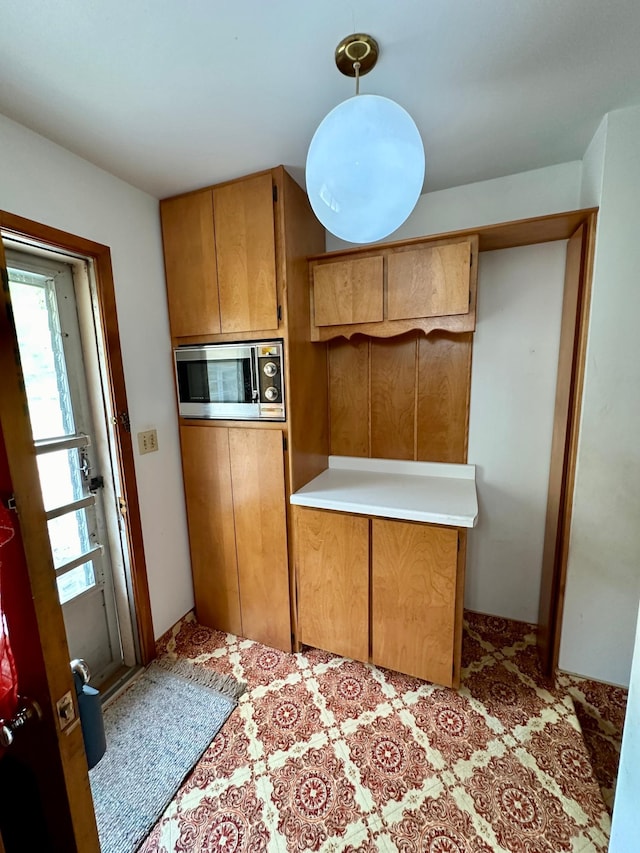 kitchen with stainless steel microwave and pendant lighting