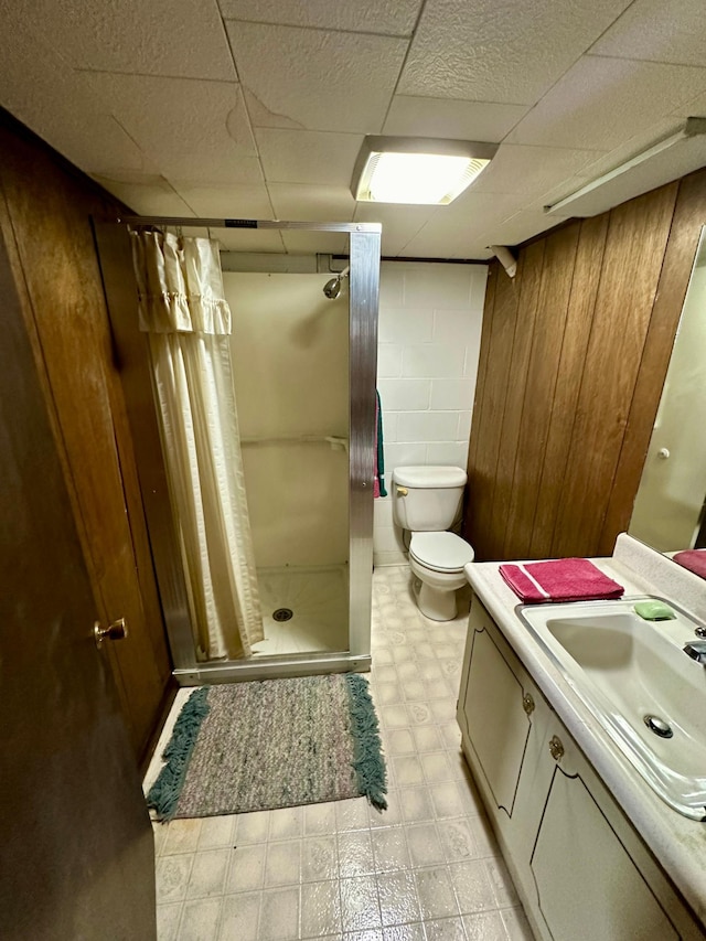 bathroom featuring tile floors, wooden walls, a shower with curtain, vanity, and toilet