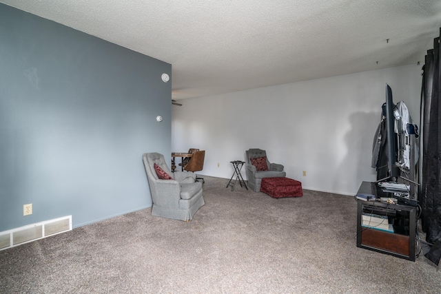 living area featuring visible vents, carpet floors, and a textured ceiling