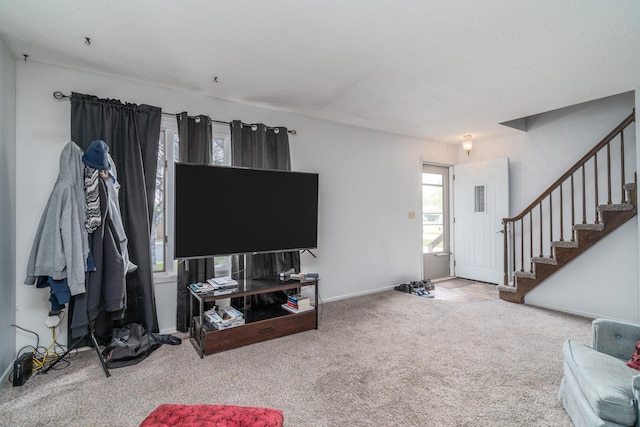 carpeted living room featuring stairway