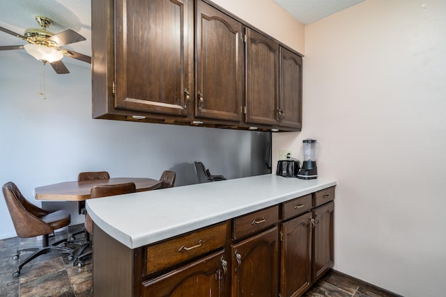 kitchen with ceiling fan, dark brown cabinets, kitchen peninsula, and a textured ceiling