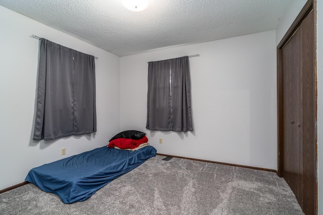 carpeted bedroom featuring a textured ceiling