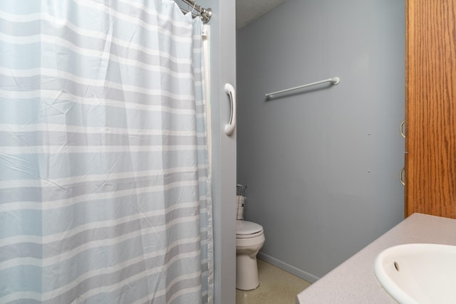 bathroom featuring vanity, toilet, and a textured ceiling