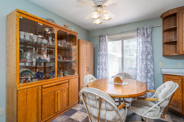 dining room featuring ceiling fan and a textured ceiling