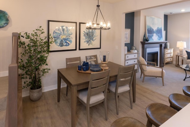 dining space featuring light hardwood / wood-style flooring and a chandelier