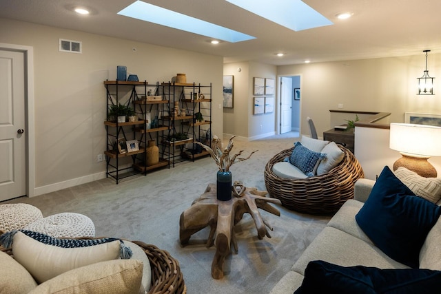 carpeted living room with a skylight and a chandelier