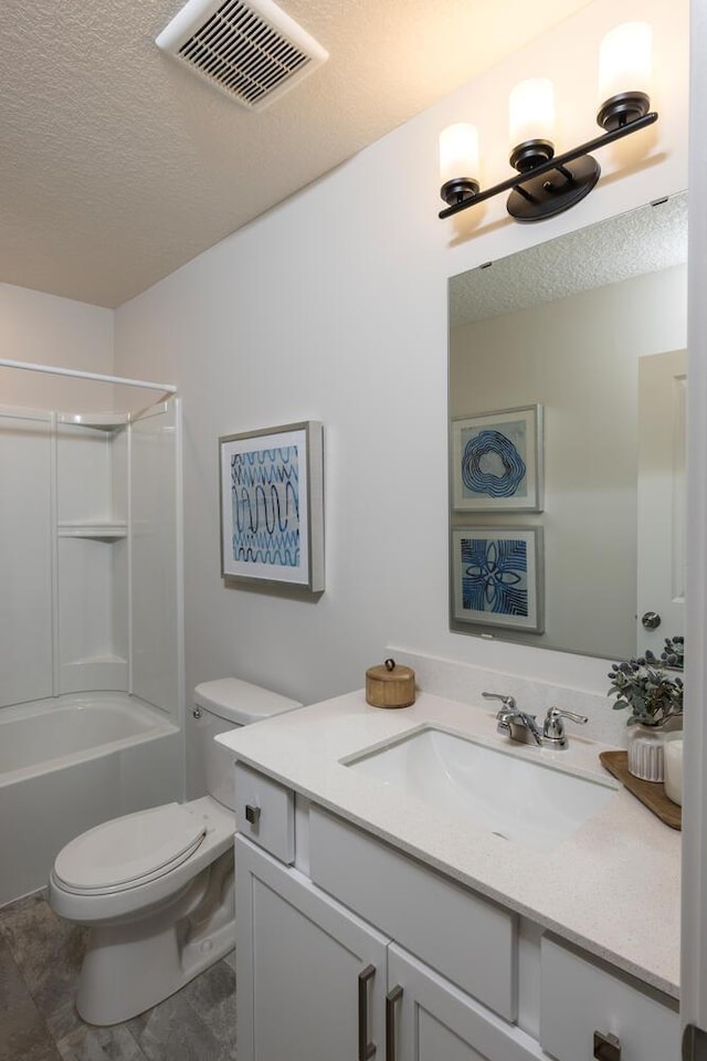 full bathroom with a textured ceiling, vanity, toilet, and shower / washtub combination