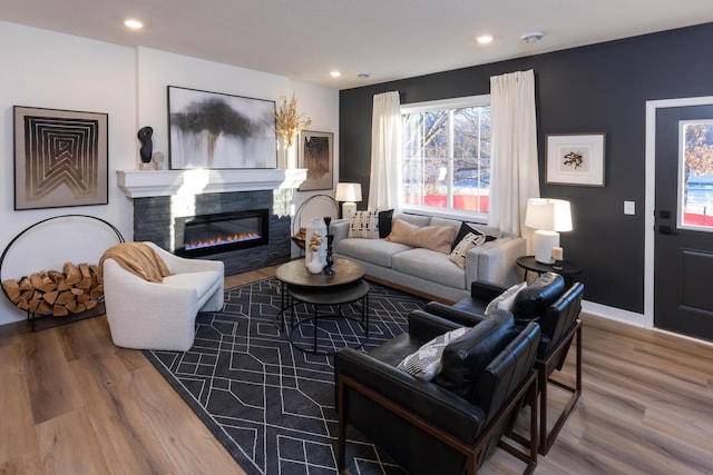 living room featuring hardwood / wood-style flooring and a tiled fireplace