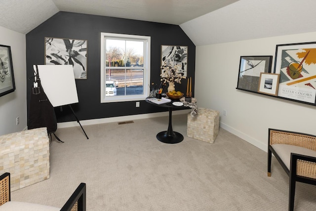 sitting room featuring vaulted ceiling, a textured ceiling, and carpet floors