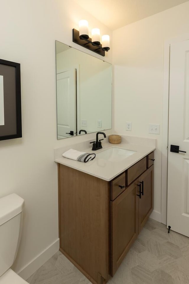 bathroom featuring tile flooring, vanity, and toilet