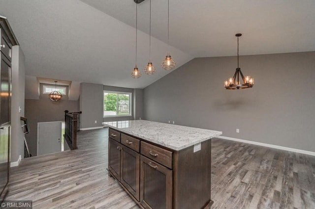 kitchen featuring pendant lighting, a center island, vaulted ceiling, dark brown cabinets, and wood-type flooring