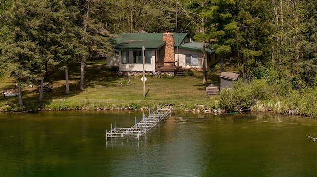 dock with a deck with water view, a lawn, and a forest view