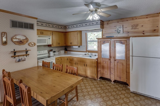 kitchen featuring light tile patterned flooring, ceiling fan, white appliances, sink, and a textured ceiling