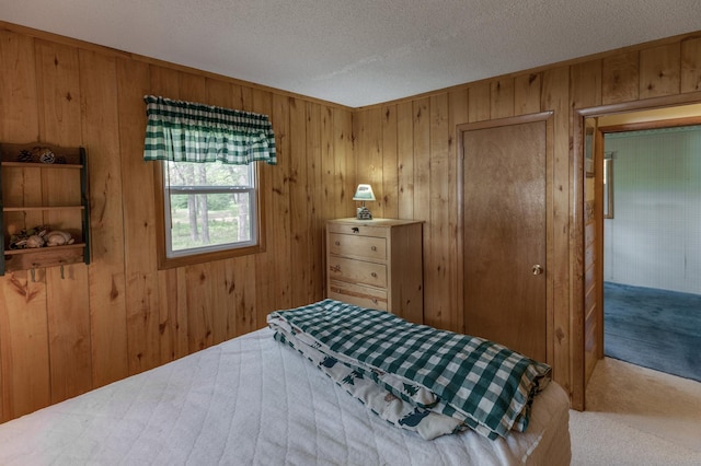 bedroom with carpet flooring, wood walls, and a textured ceiling