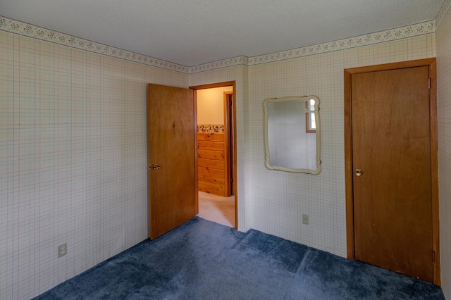 unfurnished bedroom featuring carpet and a textured ceiling