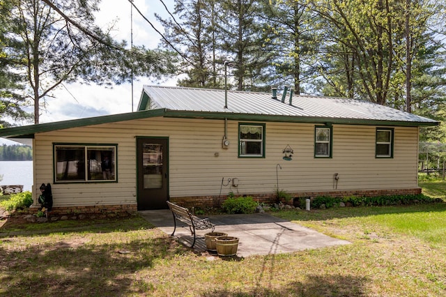 back of house featuring a patio and a yard