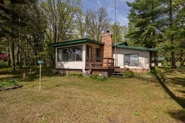 view of front facade featuring a wooden deck and a front lawn